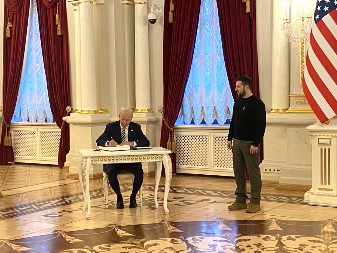 US President Joe Biden signing the guest book at the Ukrainian Presidential Palace, as Ukraine President Volodymyr Zelensky looks on.