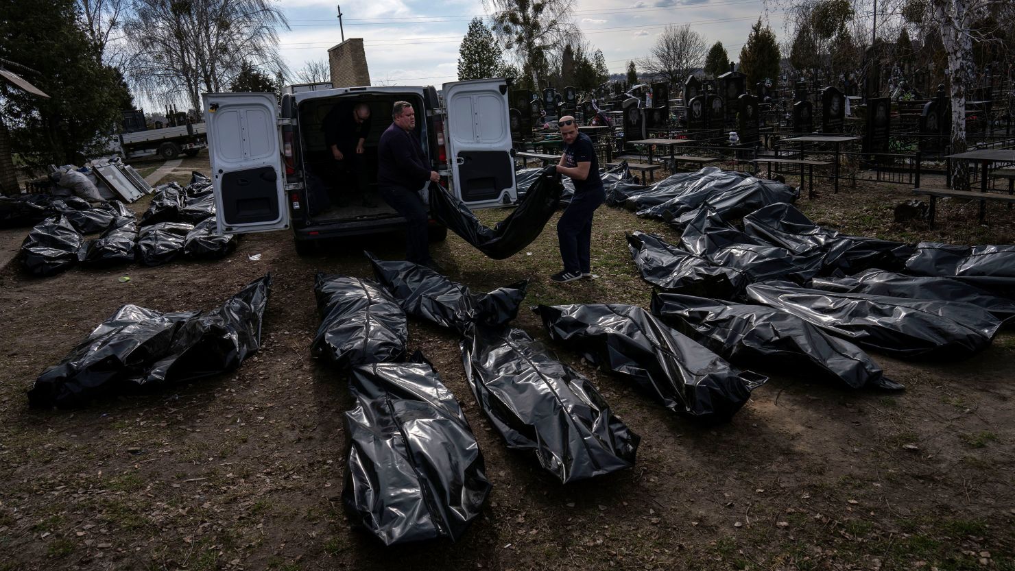 Workers unload civilian bodies in a cemetery in Bucha, Ukraine, on April 7, 2022.