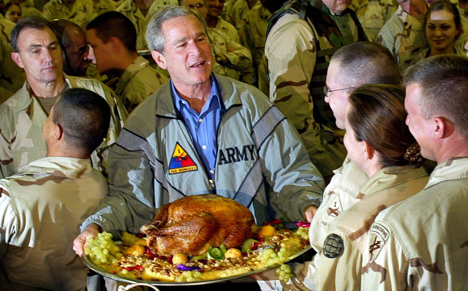 President George W. Bush holds a Thanksgiving turkey while visiting US troops stationed in Baghdad, Iraq, in November 2003. The Iraq War began in March of that year.