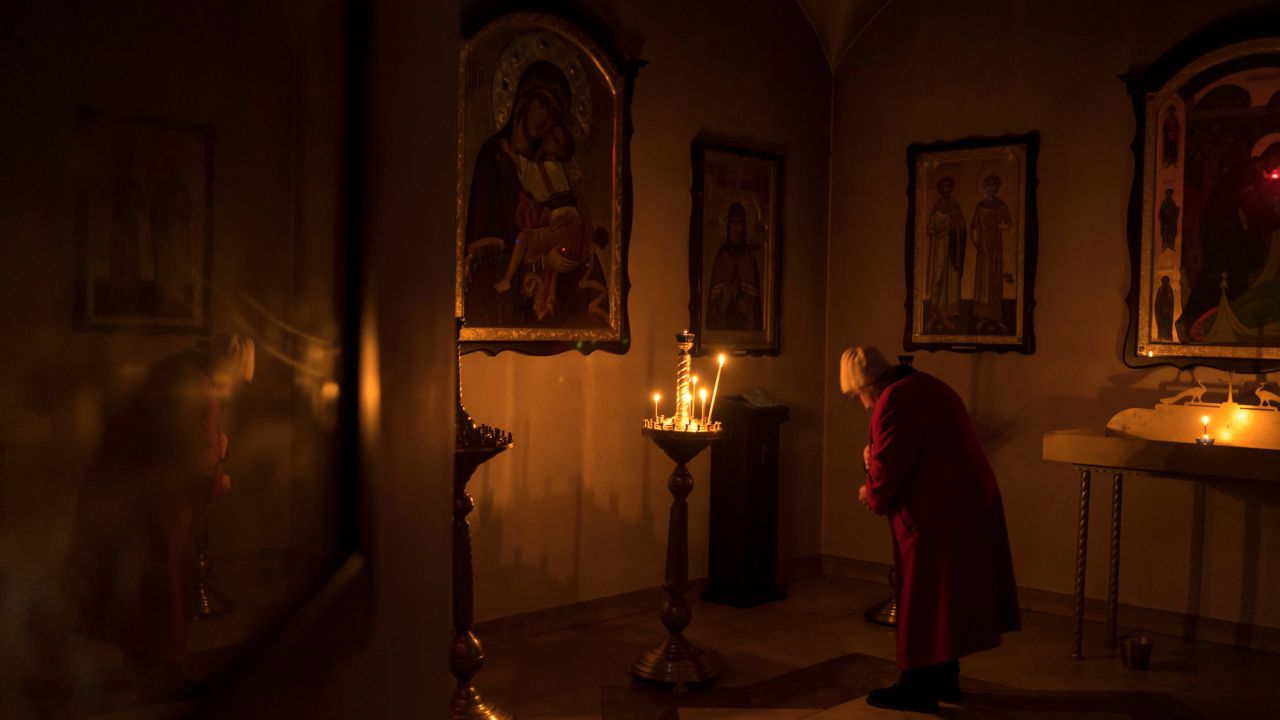 A woman prays in a basement crypt of the Church of St. Andrew.