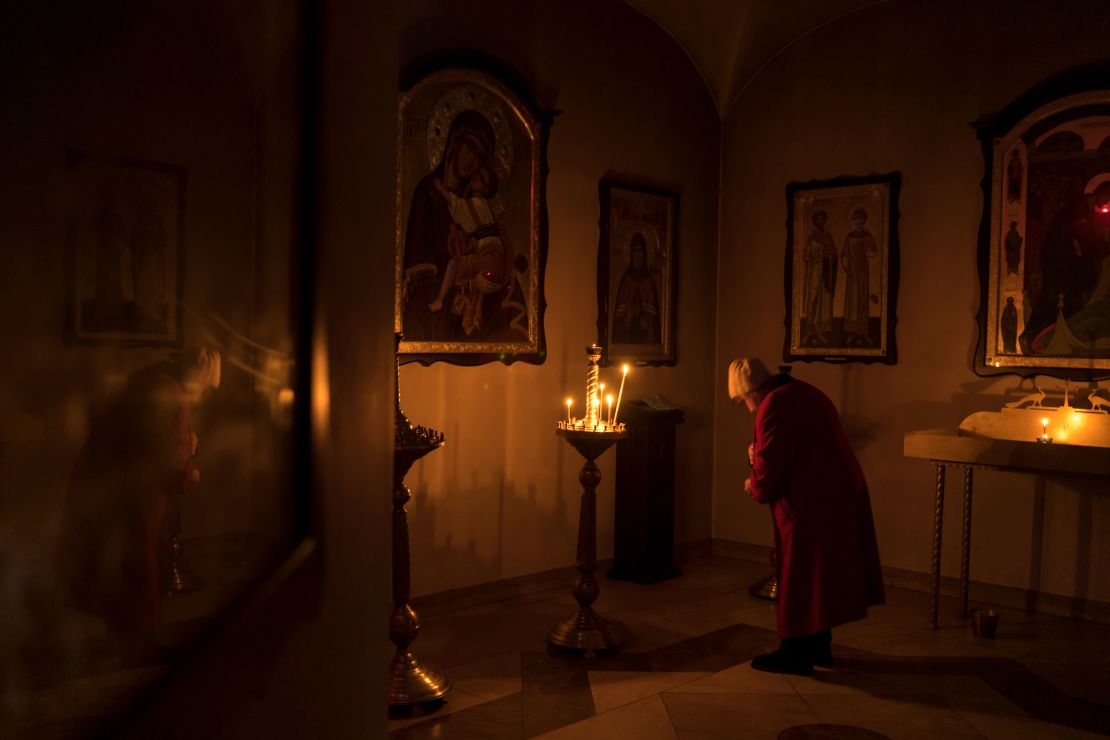 A woman prays in a basement crypt of the Church of St. Andrew.