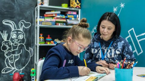 Nastia Mykolaietz watches her 9-year-old daughter, Sonya, draw at the UNICEF assistance center where she works.