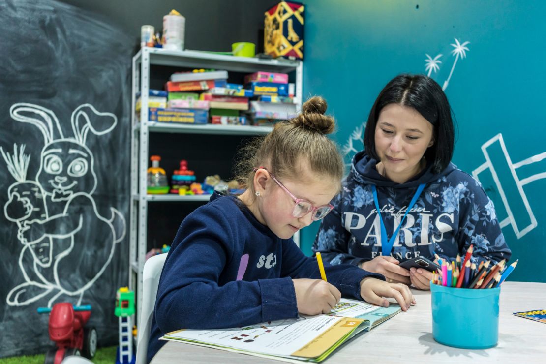 Nastia Mykolaietz watches her 9-year-old daughter, Sonya, draw at the UNICEF assistance center where she works.