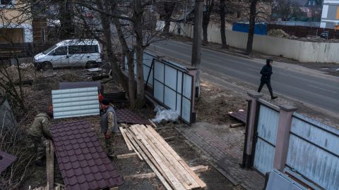 Workers cut pieces of roofing as they repair a severely damaged house in Bucha. Homes are being rebuilt with the help of foreign donors and volunteer construction workers.