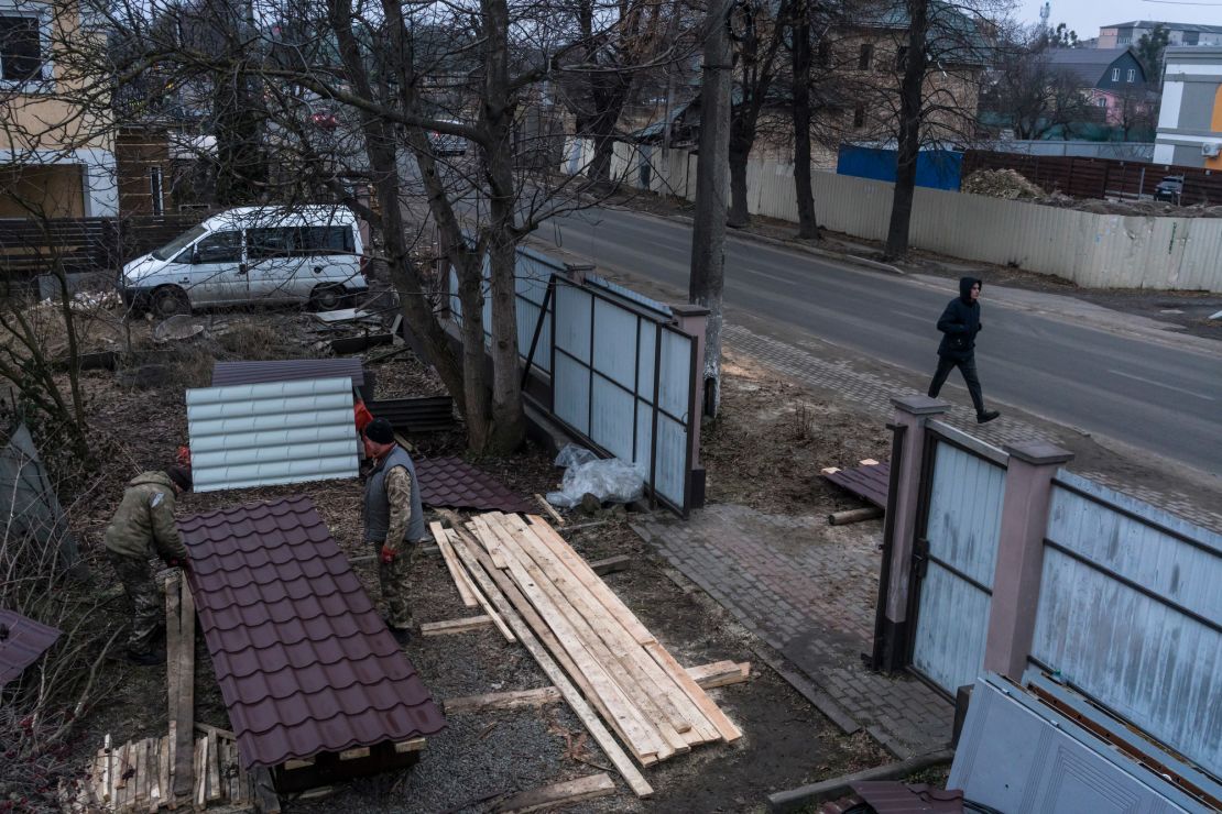 Workers cut pieces of roofing as they repair a severely damaged house in Bucha. Homes are being rebuilt with the help of foreign donors and volunteer construction workers.