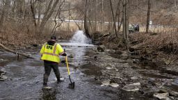 Ron Fodo, Ohio EPA Emergency Response, checks for chemicals at Leslie Run creek following the train derailment on February 20, 2023 in East Palestine, Ohio.