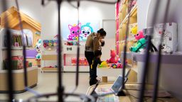 A woman carrying a baby looks at soft toys of characters from SmartStudy Co.'s Pinkfong brand at the company's store in Seongnam, South Korea, on Monday, Jan. 21, 2019. The South Korean company behind "Baby Shark (Doo Doo Doo Doo Doo Doo)", the one-and-a-half minute song about a family of sharks, is now seeking to capitalize on the success by expanding its kid-oriented entertainment business. Photographer: SeongJoon Cho/Bloomberg