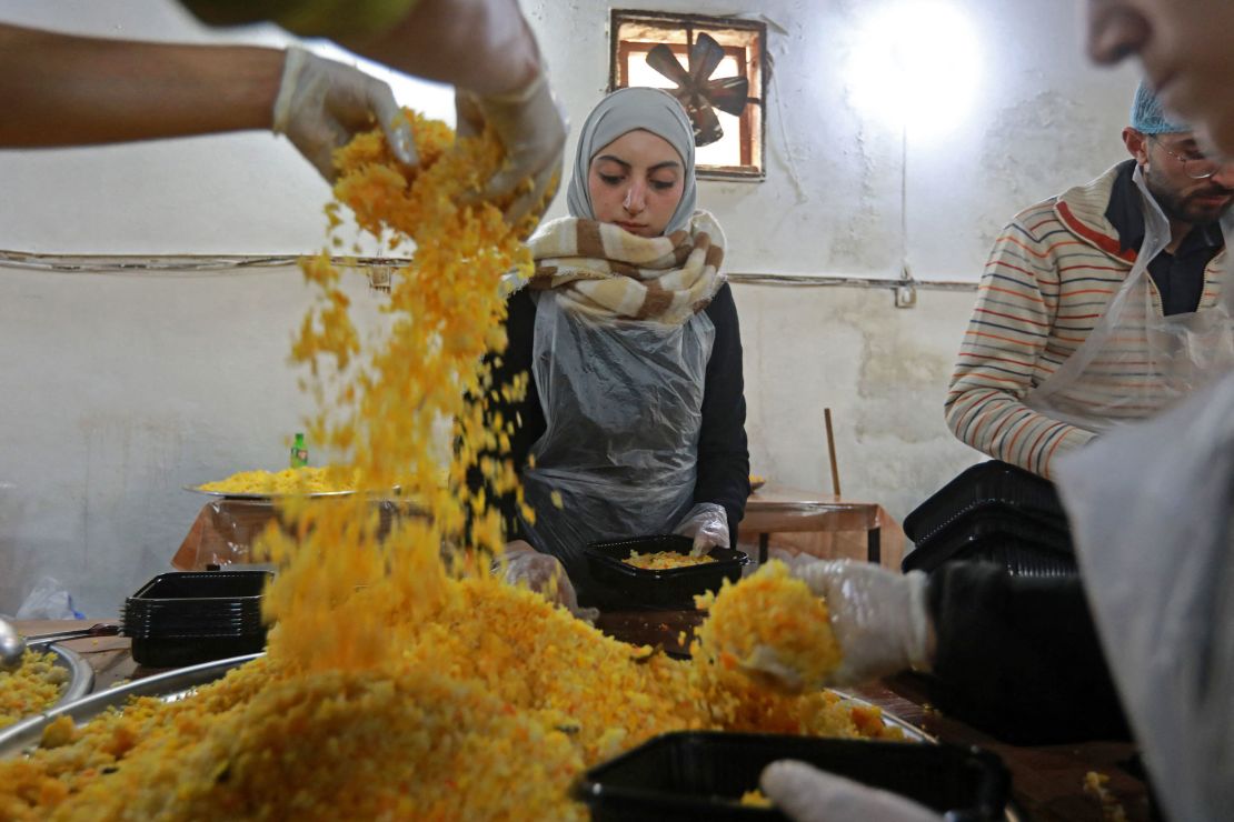 Volunteers prepare food to serve people affected by the earthquake in the government-held northern Syrian city of Aleppo on Tuesday. 