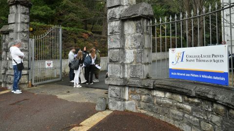Люди стоят у входа в школу Сен-Тома д'Акин в Сен-Жан-де-Люз, Франция, где учитель скончался от ножевого ранения ученика, 22 февраля 2023 года.