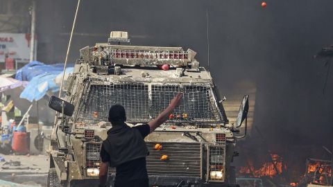 A Palestinian faces an Israeli military vehicle during a raid on the West Bank city of Nablus, on February 22, 2023. 