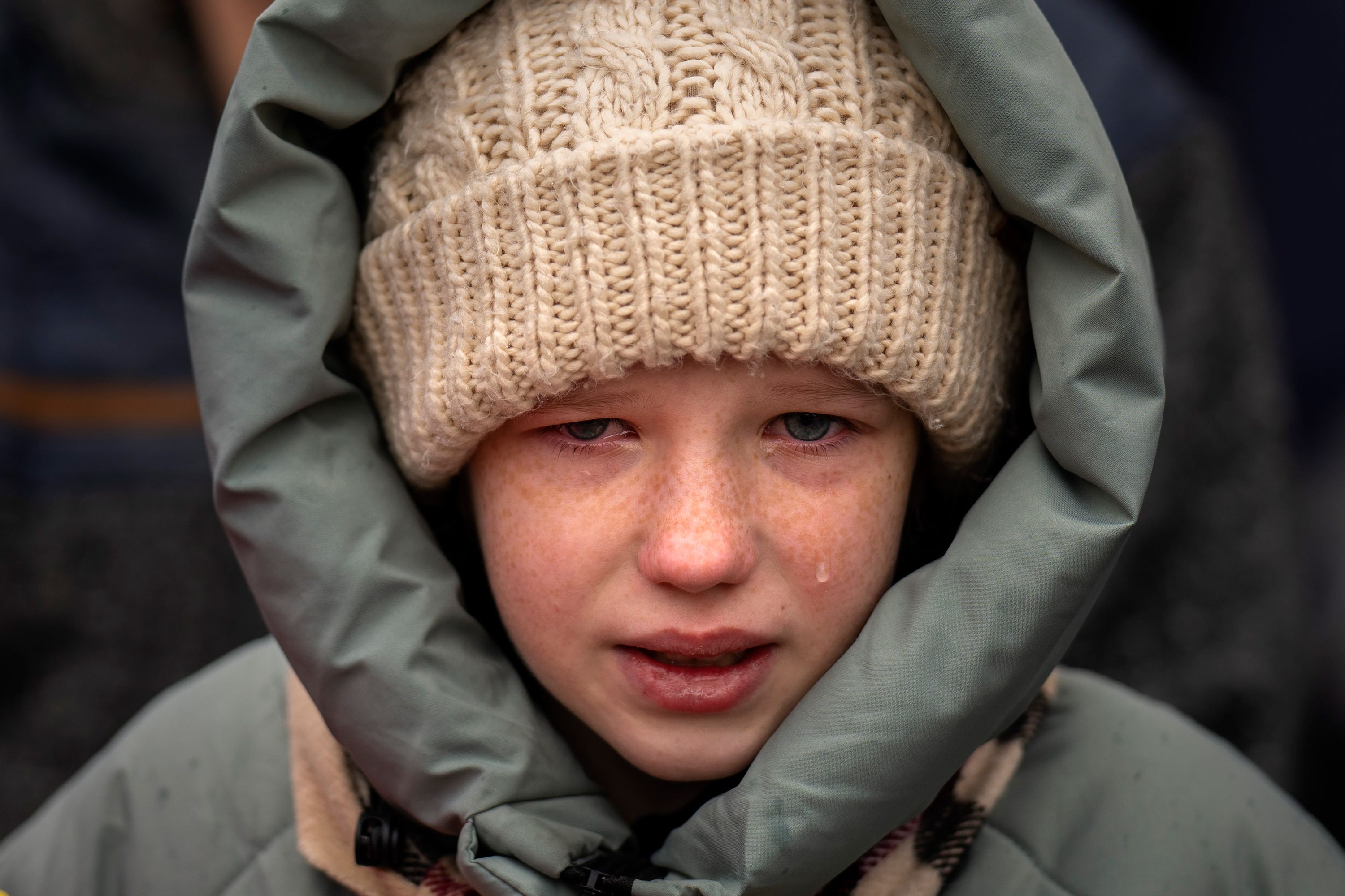 Anna, 10, cries next to the body of her brother during his funeral in Ukraine.