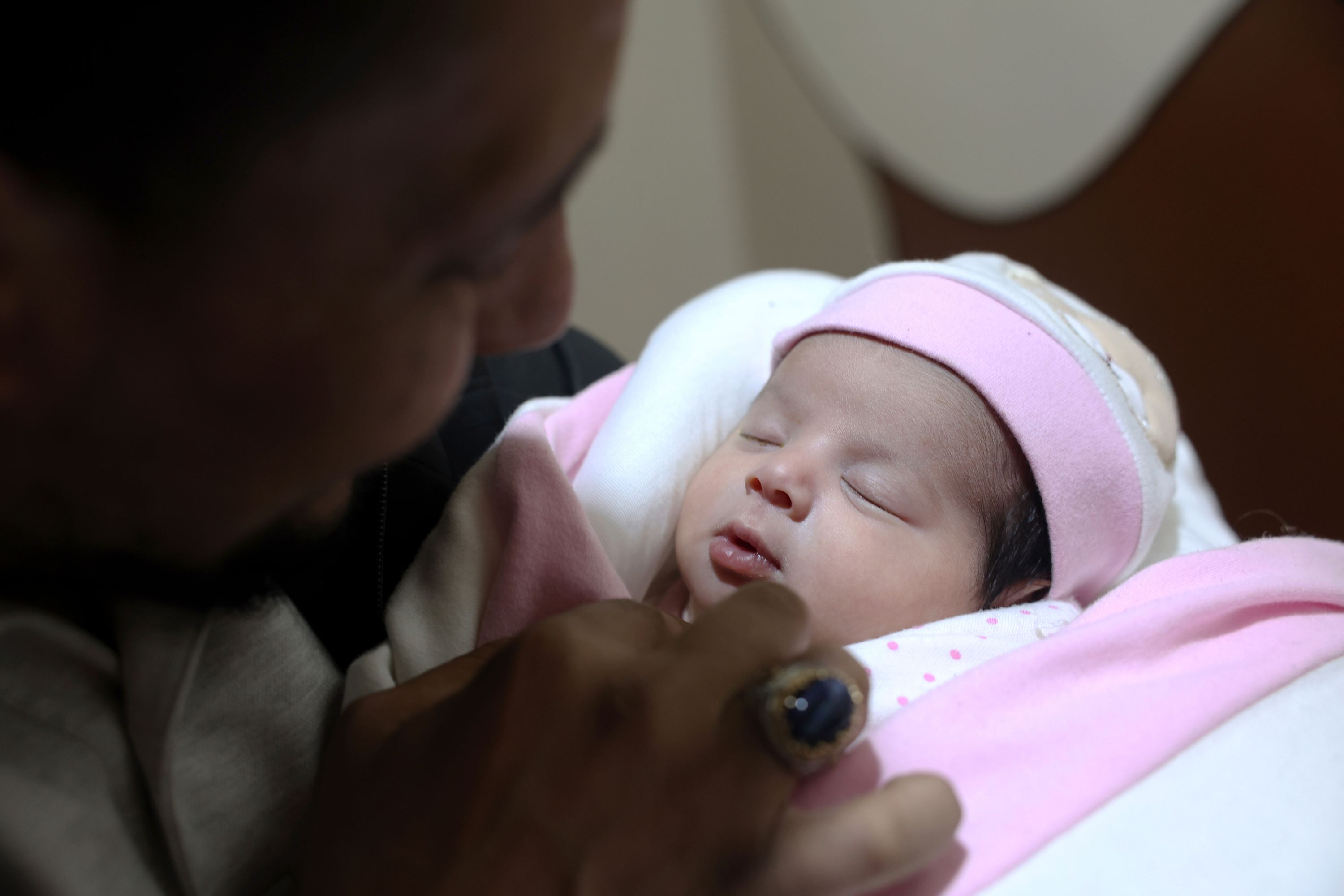 A baby girl is looked at by her rescuer after being found in northern Syria.