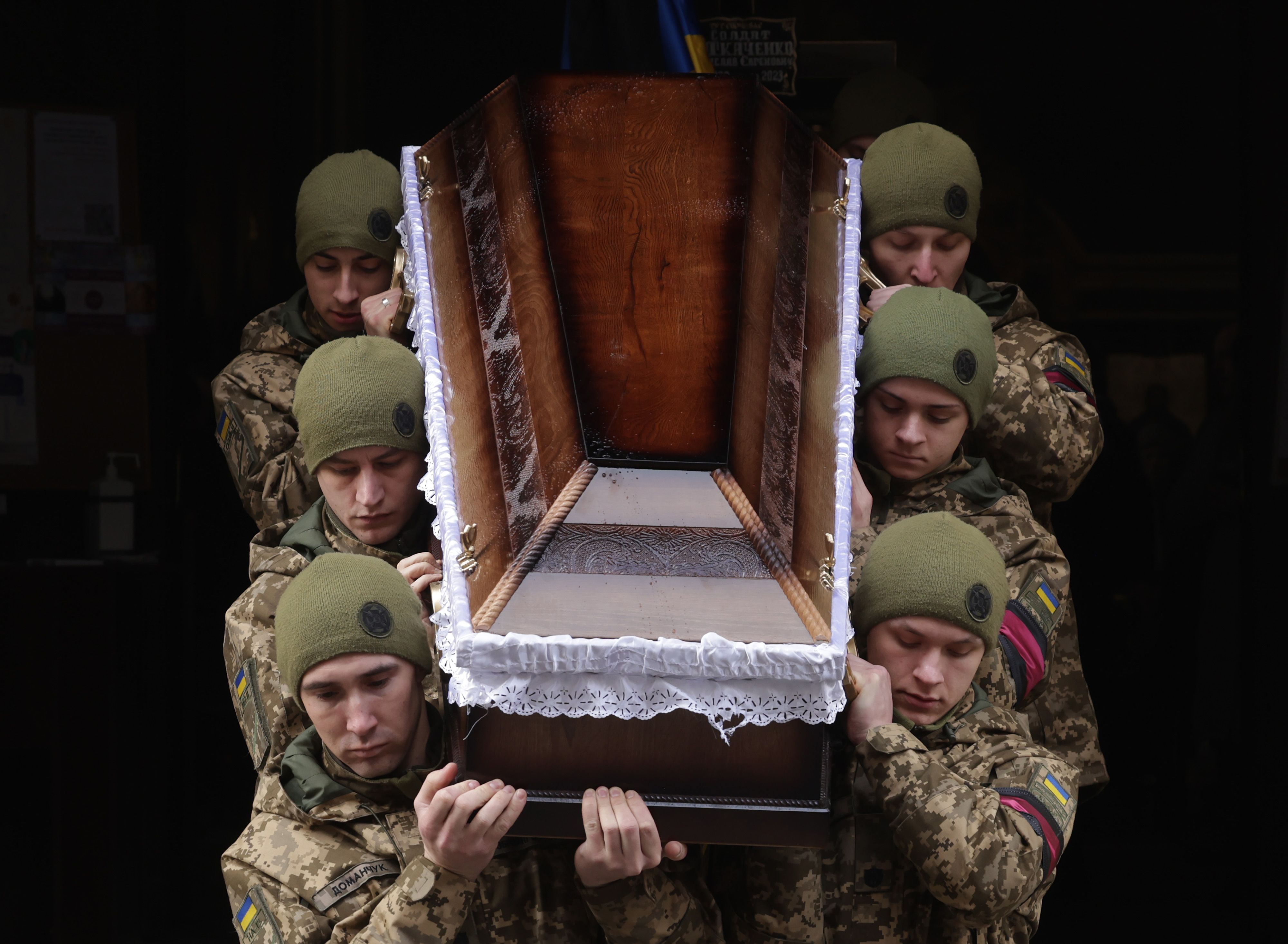 Ukrainian soldiers carry the coffin of a soldier at a funeral.