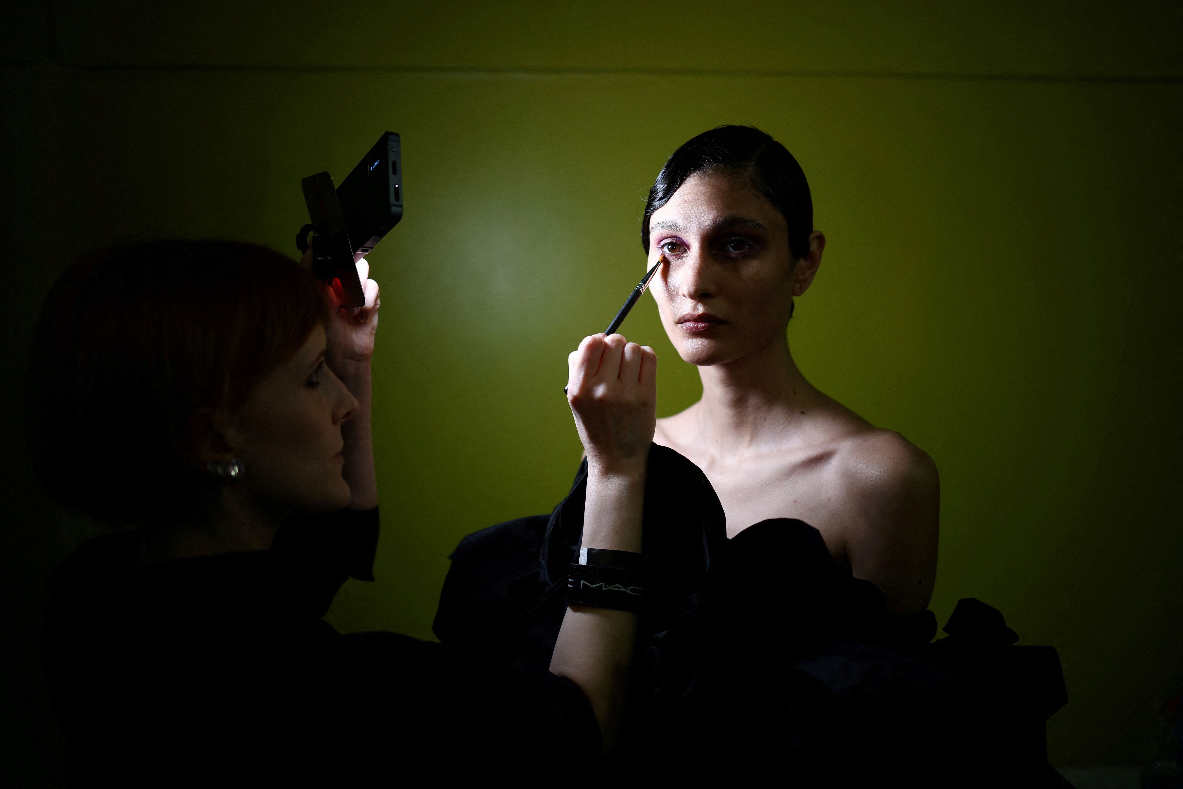 A model prepares backstage ahead of a Richard Quinn fashion show in London.