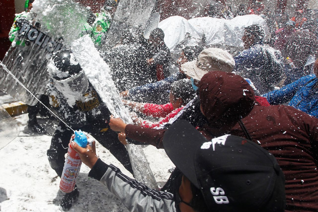 Protesters in Puno, Peru, stop their demonstration and spray police with foam and water as part of a Carnival tradition on Wednesday, February 22. Anti-government protests <a href="https://www.cnn.com/2023/02/16/americas/peru-protests-indigenous-amnesty-report-intl-latam/index.html" target="_blank">have roiled Peru since December</a>.