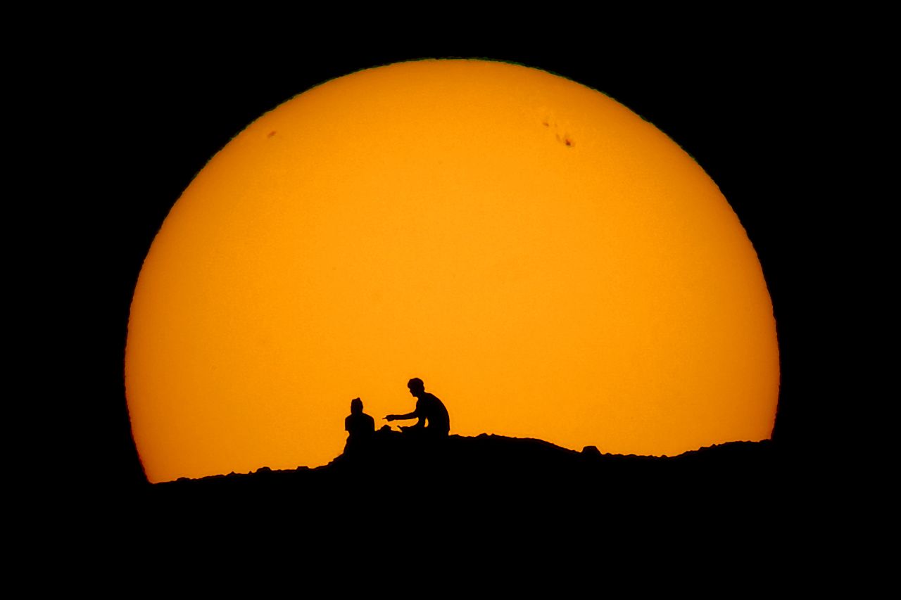 Hikers are silhouetted against the setting sun in Phoenix's Papago Park on Saturday, February 18.