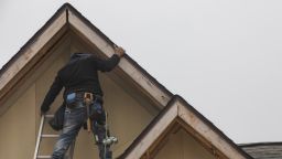 A construction worker applies trim to the roof of a new home in Foley, Alabama, US, on Wednesday, Dec. 21, 2022. 
