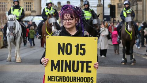 A woman holds a placard protesting 15 minute cities in Oxford, England on February 18, 2023.