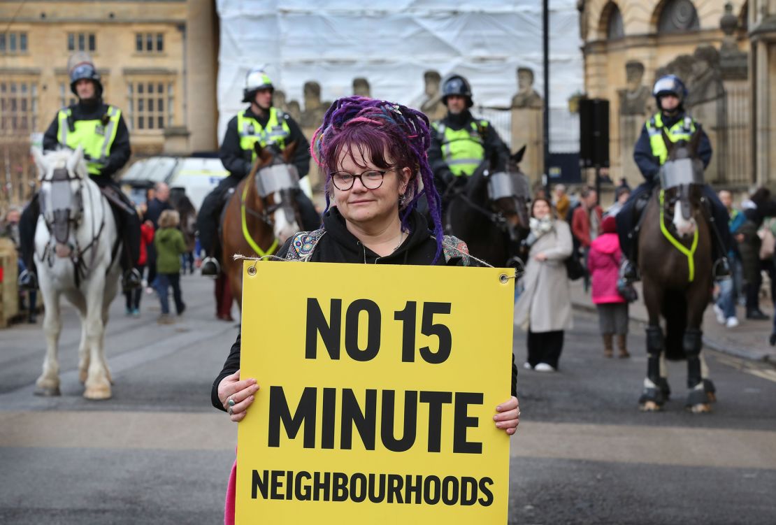 A woman holds a placard at a protest against 15-minute cities in Oxford, England on February 18, 2023.