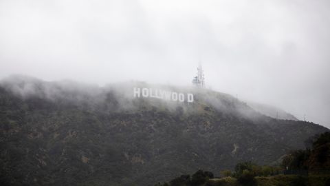 The Hollywood sign is seen through a mix of fog and dust snow during a rare cold winter storm in Los Angeles, California, on February 24, 2023. 