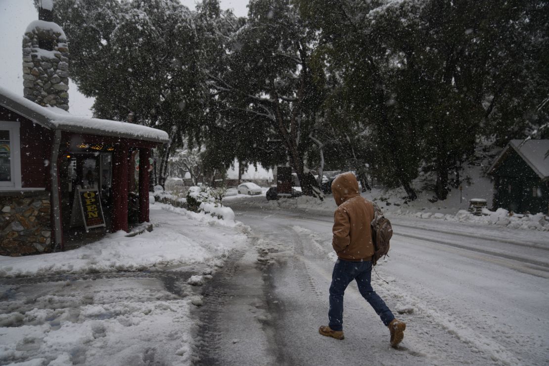 A resident walks to a restaurant during a storm in Mount Baldy, California, on Friday. 