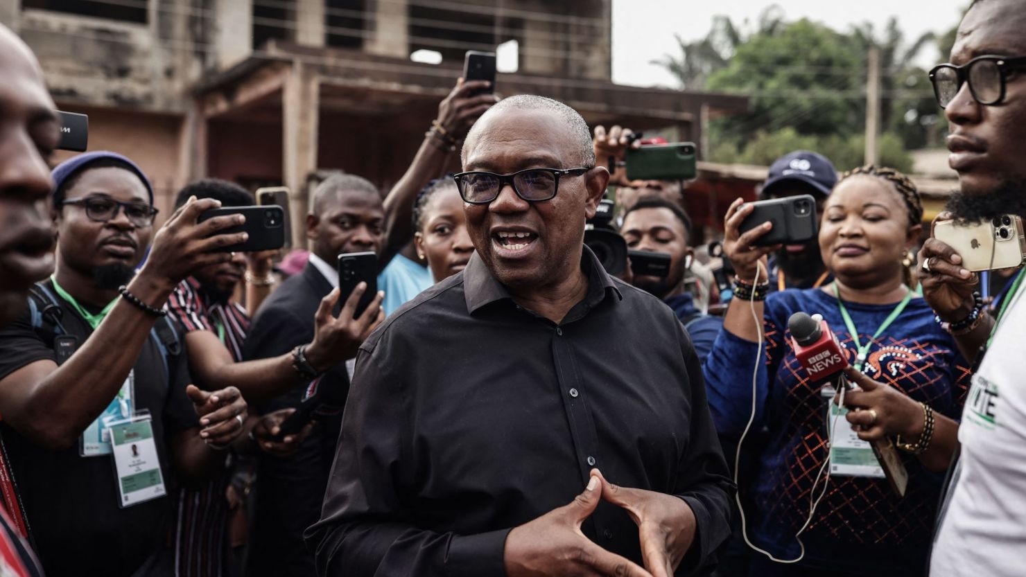 Labour Party presidential candidate Peter Obi (C) talks to the media at outside a polling station in Amatutu on Saturday, before polls opened.