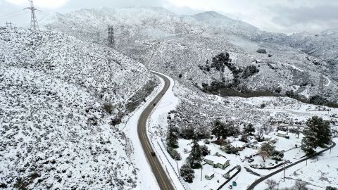 In an aerial view, drivers pass through the snow-covered Sierra Pelona Mountains in Los Angeles County. 