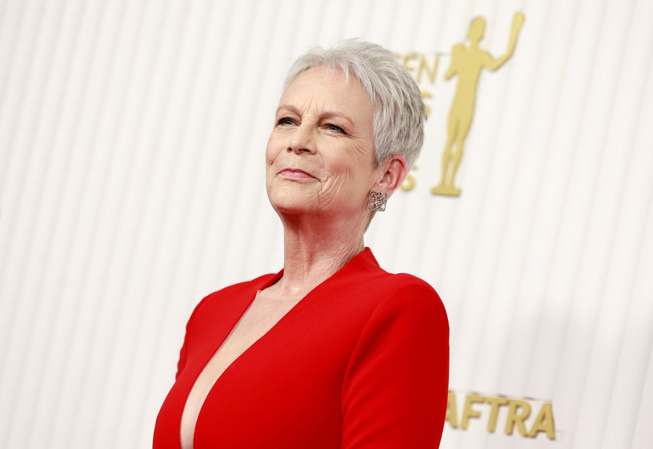 Jamie Lee Curtis wowed in a red floor-length Romona Keveza gown with a plunging neckline.