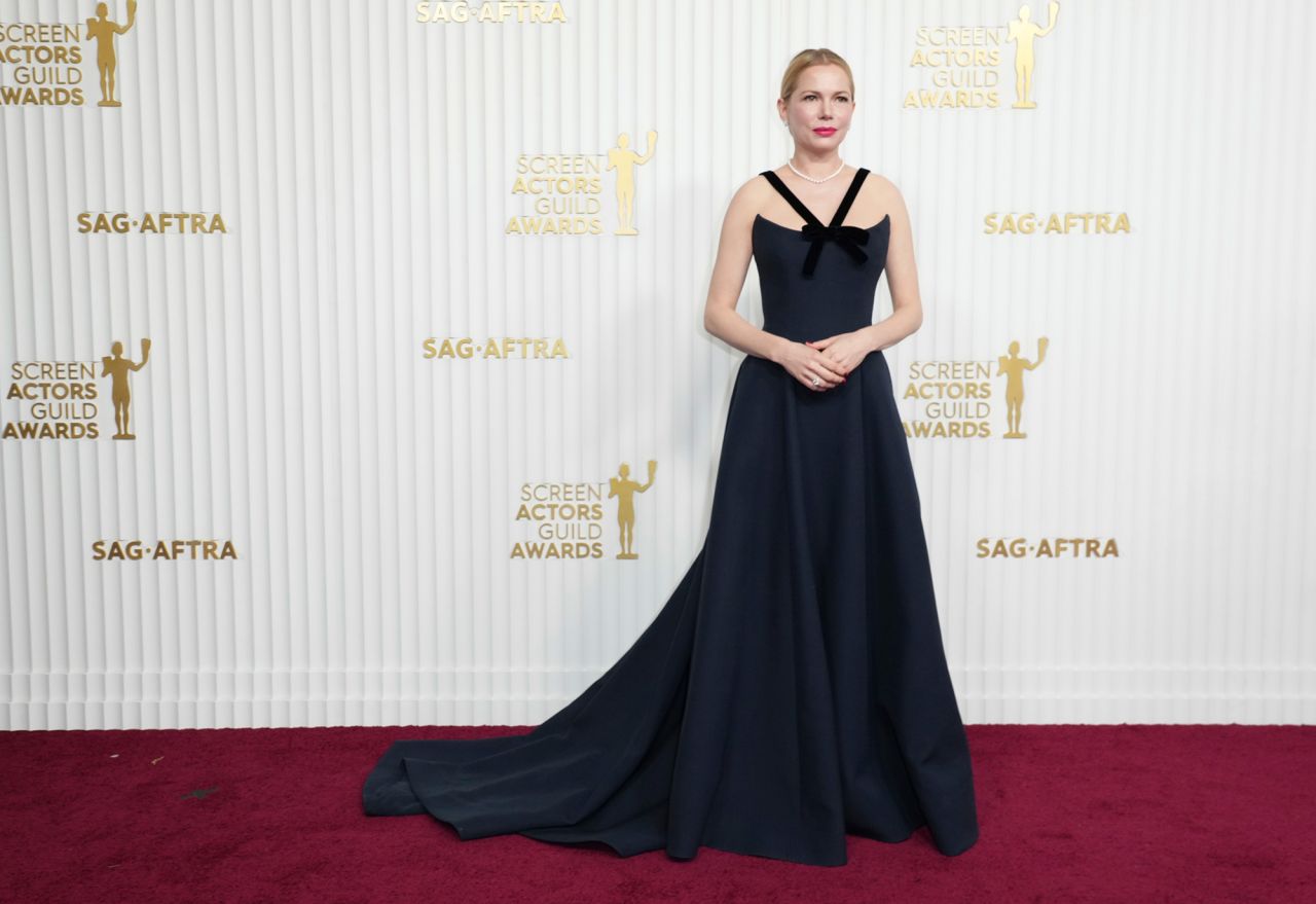 Michelle Williams in an elegant navy Dior dress with a velvet bow.