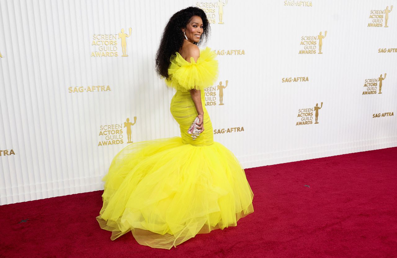 Angela Bassett in a Giambattista Valli Haute Couture yellow tulle dress with mermaid skirt and ruffled sleeves.