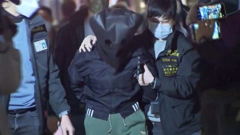 Petugas polisi di Hong Kong pada hari Minggu mengawal seorang tersangka berusia 47 tahun sehubungan dengan pembunuhan Choi, yang menarik perhatian kota selama akhir pekan.