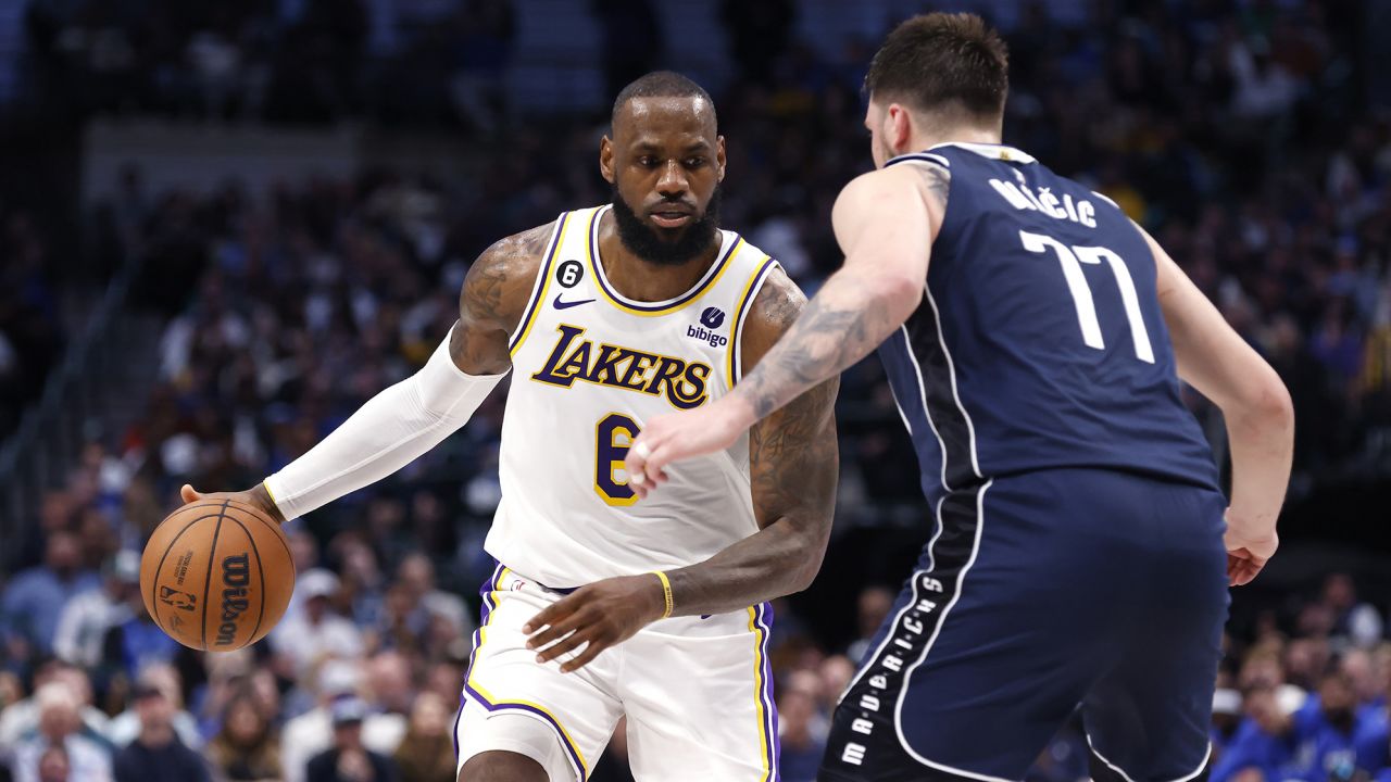 LeBron James of the Los Angeles Lakers handles the ball as Luka Dončić of the Dallas Mavericks defends. 