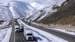 Truckers drive State Route 58 across the southern Sierra Nevada Mountains following its reopening in the wake of a powerful storm that brought snow to unusually low elevations on February 26, 2023 near Mojave, California.