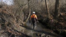 A member of the Environmental Protection Agency takes water samples from Sulphur Run creek following a train derailment in East Palestine, Ohio, US, on Thursday, February 23, 2022. 