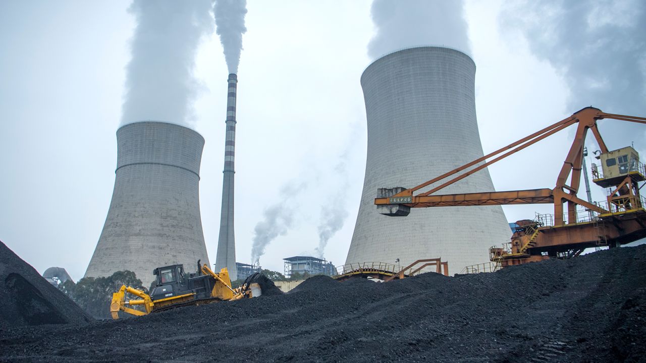 A bulldozer pushes coal onto a conveyor belt at the Jiangyou Power Station on January 28, 2022 in China's Sichuan province. 