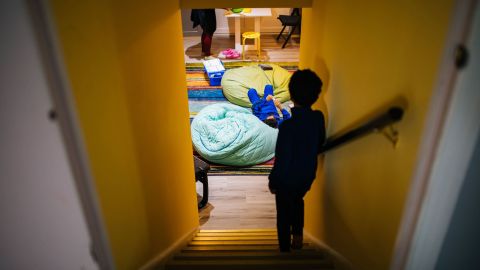 Gabriel Mehta stands on the stairs while his brother Caleb lounges on a bean bag chair during a break between lessons.