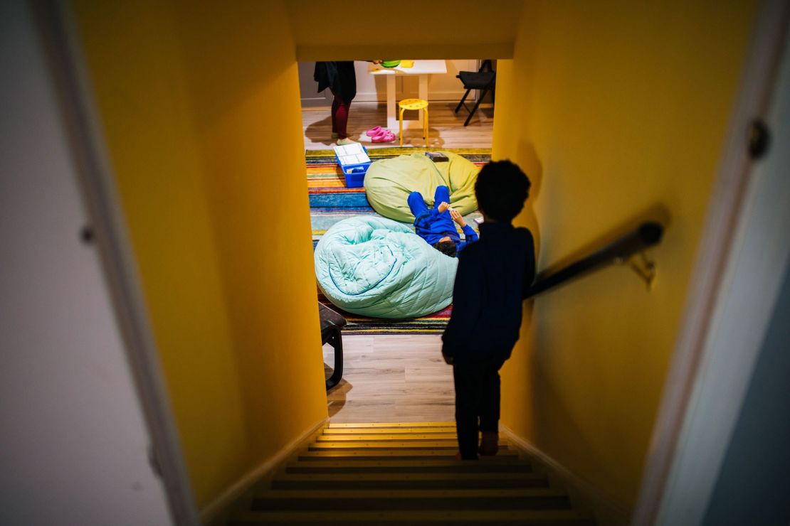 Gabriel Mehta stands on the stairs while his brother Caleb lounges on a bean bag chair during a break between lessons.