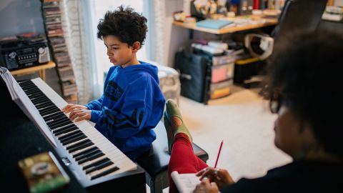 Sherri Mehta watches Caleb practice the piano.