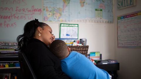 Bean holds her son, Khari, in her arms while they look at a map of the world. The book they were reading mentioned Paris so she asked him if he could point to it on a map.