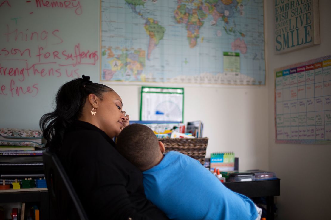 Bean holds her son, Khari, in her arms while they look at a map of the world. The book they were reading mentioned Paris so she asked him if he could point to it on a map.