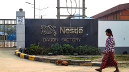 Жена се разхожда пред портата на фабриката на Nestle в индустриалната зона Dagon Seikkan в Янгон на 28 февруари 2023 г.