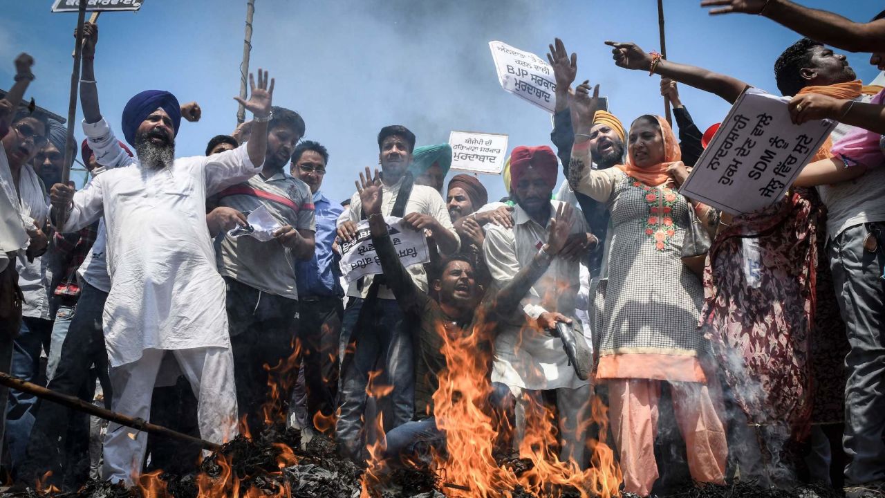 Supporters of Aam Aadmi Party take part in a demonstration held in Amritsar on August 31, 2021 following clashes between police and farmers.