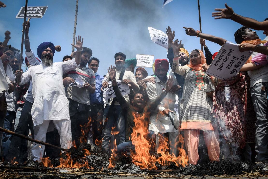 Supporters of Aam Aadmi Party take part in a demonstration held in Amritsar on August 31, 2021 following clashes between police and farmers.