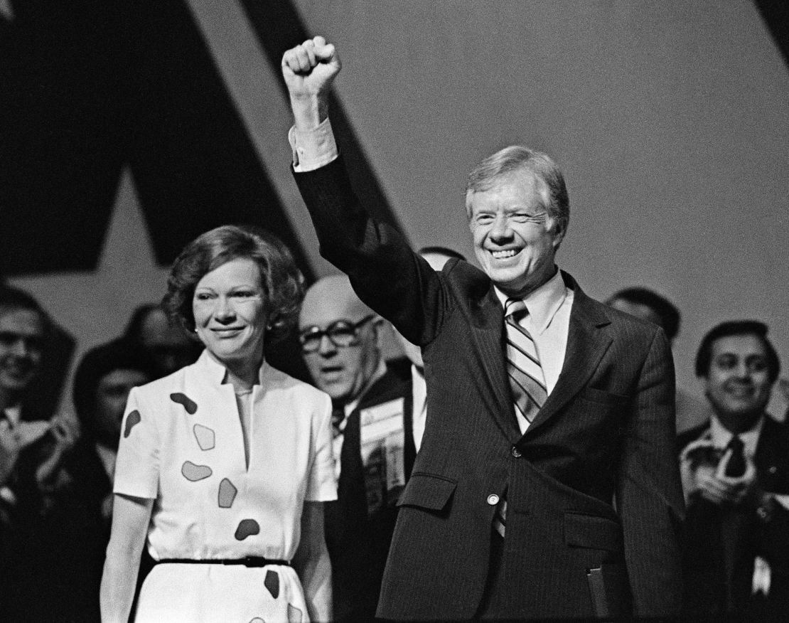 President Jimmy Carter raises his fist as he stands with his wife, First Lady Rosalynn Carter, after addressing the 118th annual National Education Association (NEA) Convention in Los Angeles on July 3, 1980. 