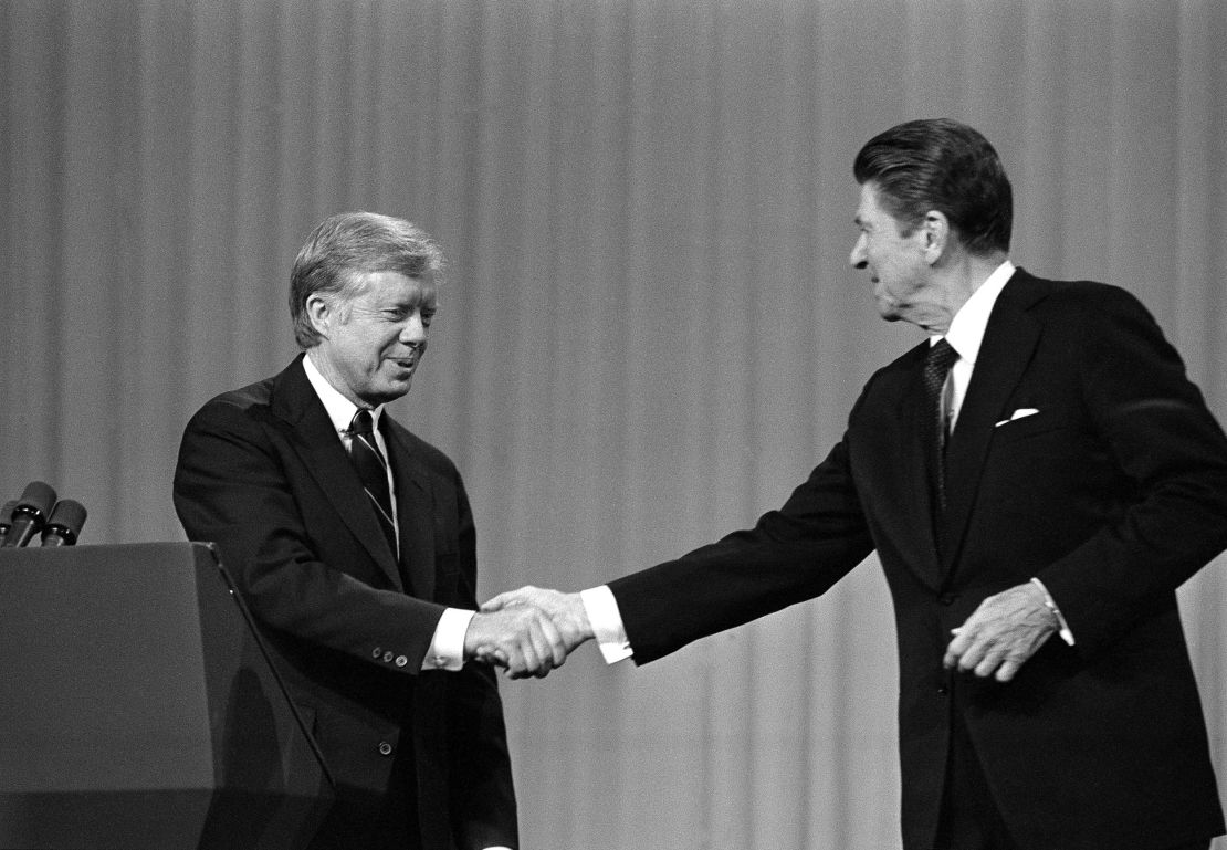 ADVANCE FOR MONDAY, SEPT. 5 AND THEREAFTER -FILE - In this Oct. 28, 1980 file photo, President Jimmy Carter shakes hands with Republican Presidential candidate Ronald Reagan after debating in the Cleveland Music Hall in Cleveland. The fall debates are always a big part of any presidential campaign. But with many 2016 voters underwhelmed by both Hillary Clinton and Donald Trump, this year's debates could well be more influential than usual. In 1980, a cheerful Reagan shone in his debate against Carter, scolding him with a gentle "There you go again," and posing a pointed closing question: "Are you better off than you were four years ago?"