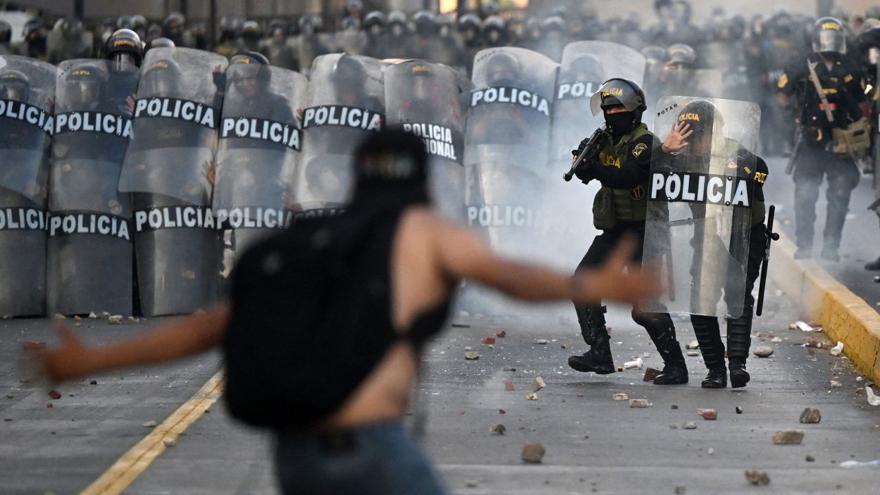 Demonstrators and riot police clash in Lima on January 24.