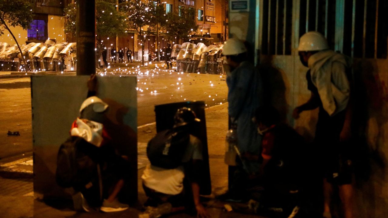 Protesters in Lima shelter behind improvised shields on February 4.