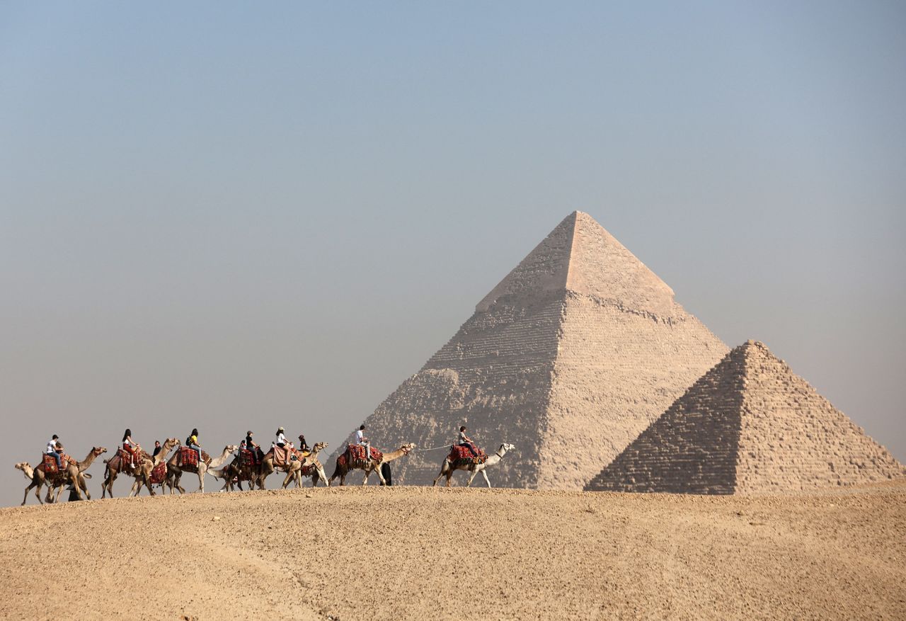 Tourists ride camels in front of the Great Pyramids plateau in Giza, Egypt, in December. 