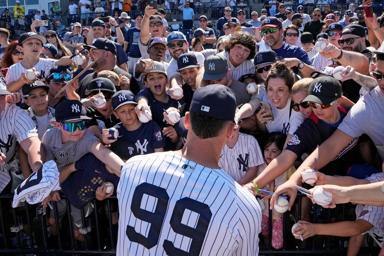 New York Yankees right fielder Aaron Judge signs autographs for fans before a spring training baseball game against the Atlanta Braves in Tampa, Florida, on Sunday, February 26.