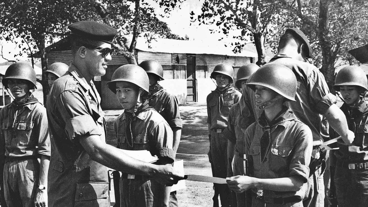 Capt. Paris Davis congratulates a soldier assigned to the 883rd Regional Forces for completing training, Vietnam, 1965. (Photo by Ron Deis)